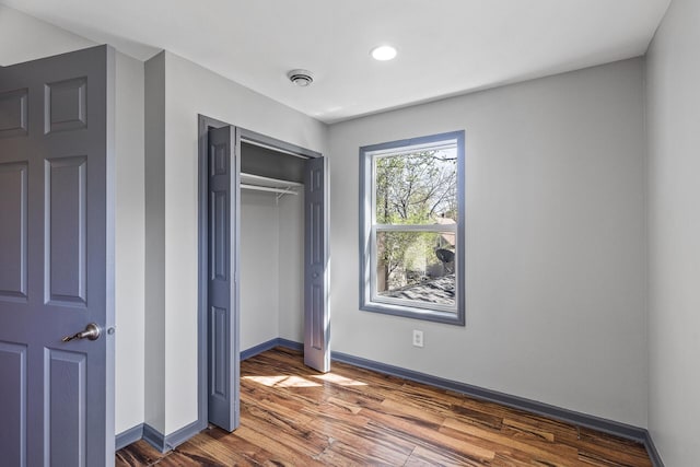 unfurnished bedroom with dark wood-style floors, baseboards, a closet, and recessed lighting