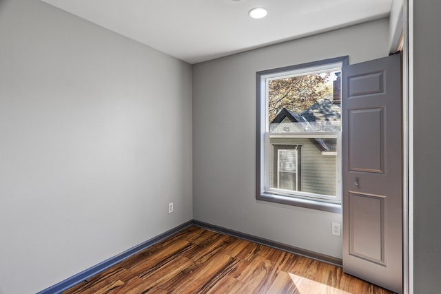 spare room featuring dark wood-style floors, recessed lighting, and baseboards