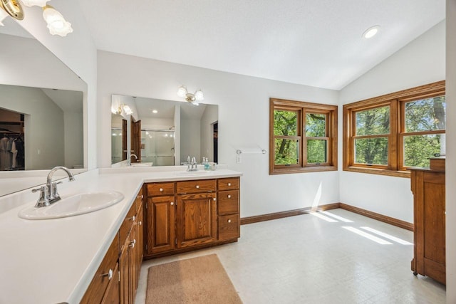 bathroom featuring lofted ceiling, a stall shower, tile patterned floors, vanity, and baseboards