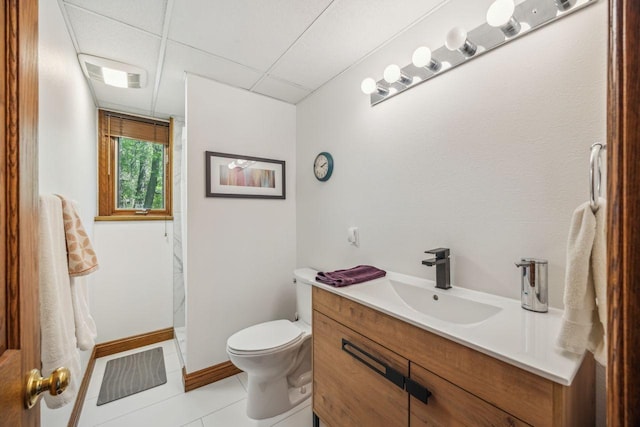 full bath featuring a paneled ceiling, tile patterned floors, a shower, vanity, and toilet