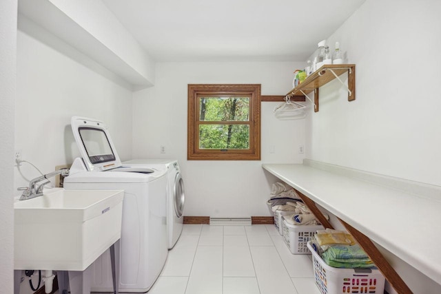 laundry room featuring washer and clothes dryer, baseboards, and light tile patterned floors