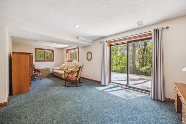 living room with carpet, baseboards, and a textured ceiling