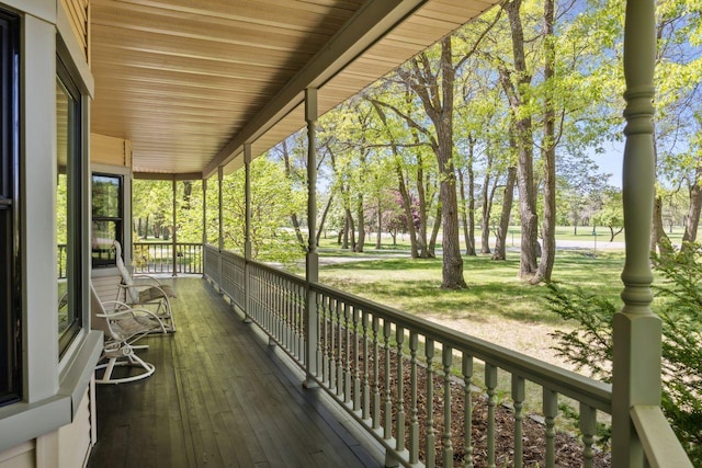 deck with a porch and view of scattered trees