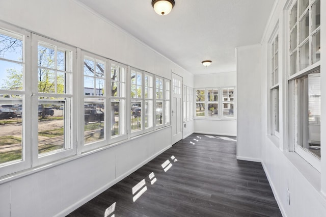 unfurnished sunroom with baseboards, wood finished floors, and french doors