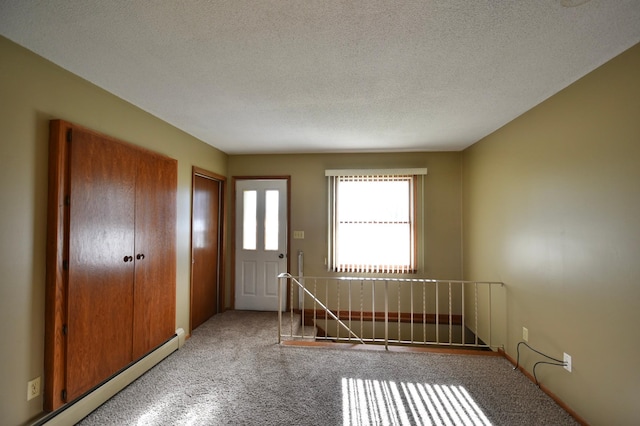 536 3rd Ave, Wanamingo, MN 55983 - entrance foyer featuring a baseboard radiator, carpet, and a textured ceiling