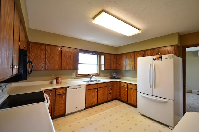 536 3rd Ave, Wanamingo, MN 55983 - kitchen featuring white appliances, a sink, brown cabinets, and light countertops