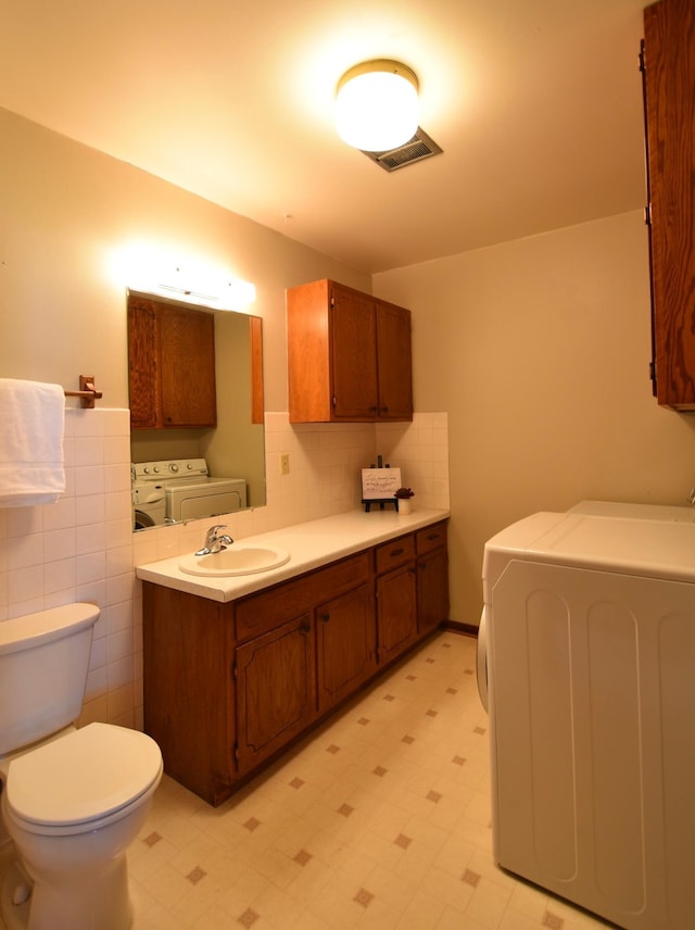 536 3rd Ave, Wanamingo, MN 55983 - bathroom with independent washer and dryer, tile patterned floors, toilet, and vanity