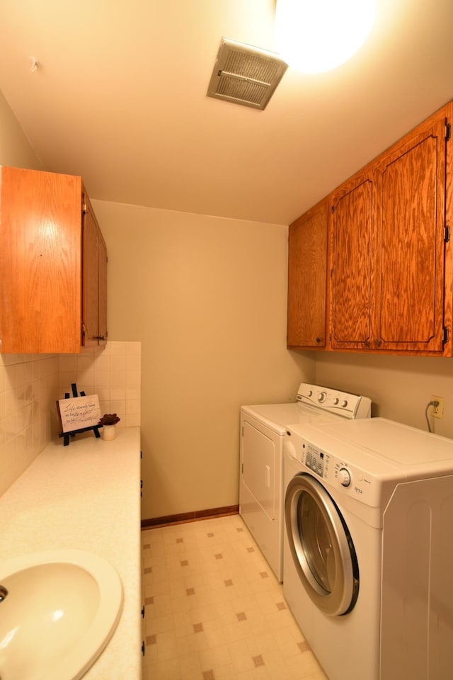 536 3rd Ave, Wanamingo, MN 55983 - clothes washing area with washing machine and dryer, light floors, baseboards, and cabinet space