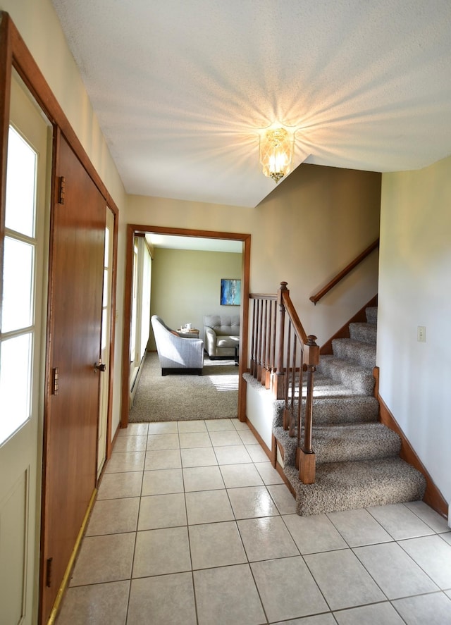536 3rd Ave, Wanamingo, MN 55983 - foyer featuring stairway, light tile patterned floors, a chandelier, and light carpet