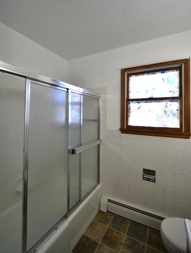 536 3rd Ave, Wanamingo, MN 55983 - bathroom with baseboard heating, toilet, shower / bath combination with glass door, and stone finish flooring