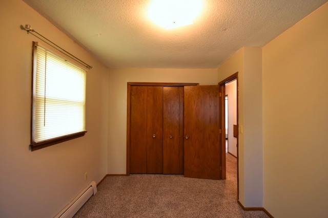 536 3rd Ave, Wanamingo, MN 55983 - unfurnished bedroom featuring a textured ceiling, carpet, a closet, and baseboard heating
