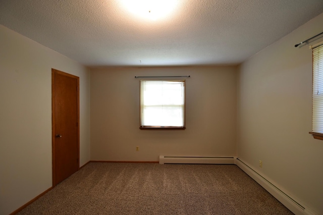 536 3rd Ave, Wanamingo, MN 55983 - carpeted empty room with a baseboard heating unit, plenty of natural light, a textured ceiling, and baseboards