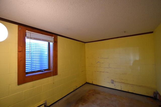 536 3rd Ave, Wanamingo, MN 55983 - empty room with a textured ceiling, concrete block wall, concrete floors, and ornamental molding