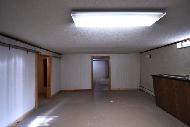 536 3rd Ave, Wanamingo, MN 55983 - basement with a baseboard radiator, concrete block wall, a textured ceiling, and baseboards
