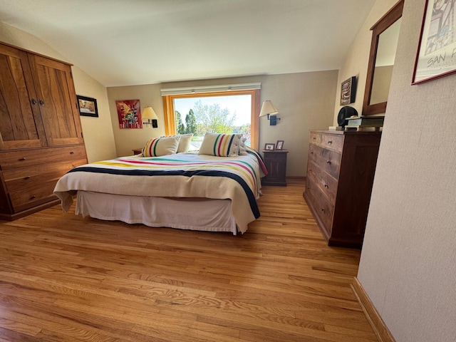 bedroom featuring lofted ceiling and light wood finished floors
