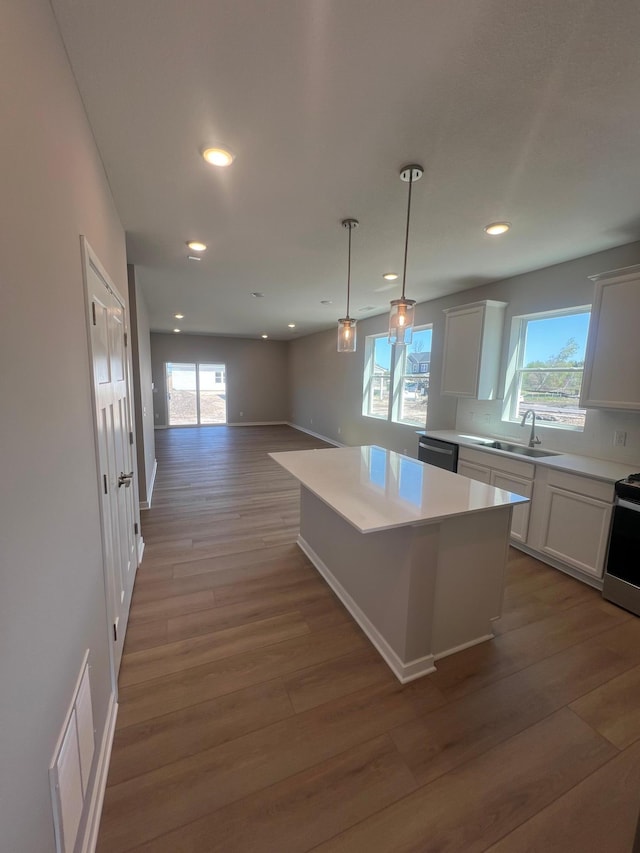 12515 Erskin St NE, Blaine, MN 55449 - kitchen featuring a sink, wood finished floors, a kitchen island, light countertops, and recessed lighting