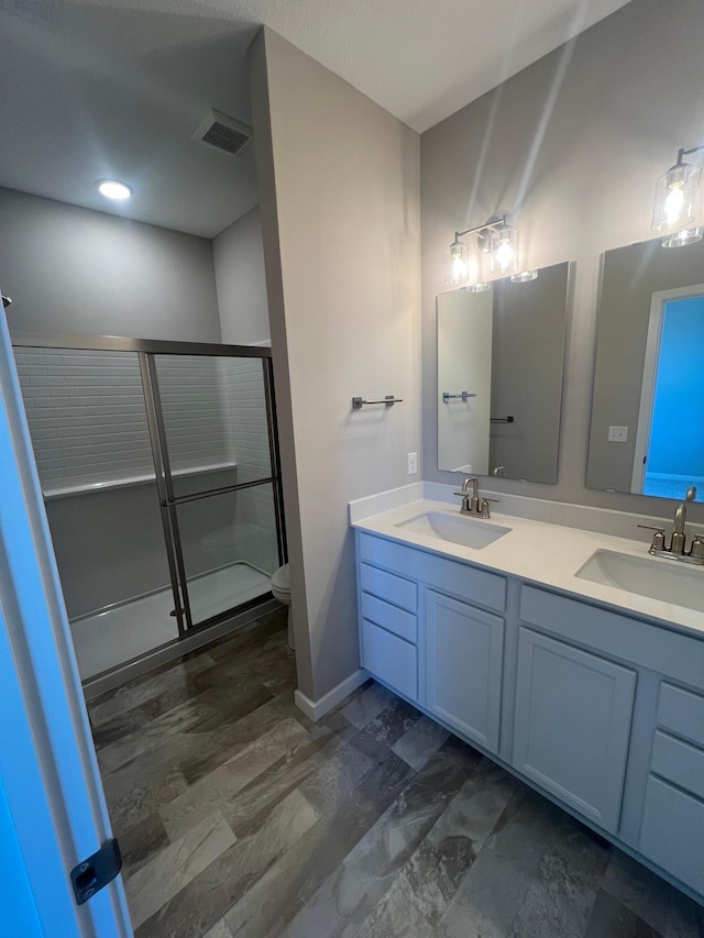 12515 Erskin St NE, Blaine, MN 55449 - full bathroom featuring a stall shower, double vanity, toilet, and baseboards