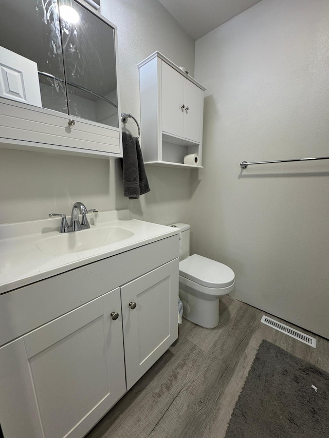 709 Center St E, Roseau, MN 56751 - bathroom with wood finished floors, toilet, and vanity