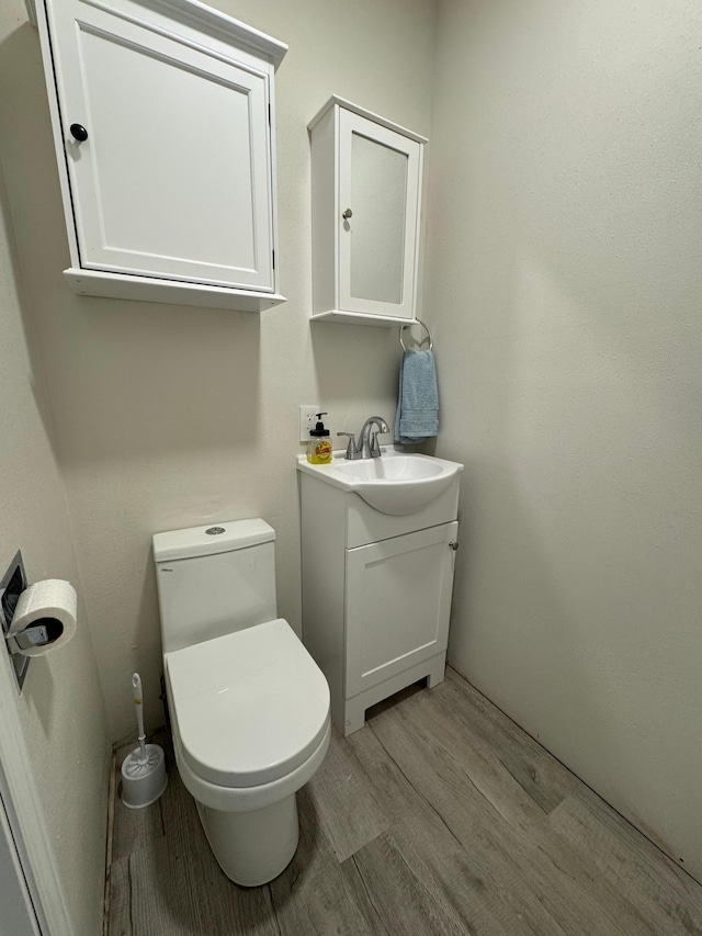 709 Center St E, Roseau, MN 56751 - half bathroom featuring wood finished floors, vanity, and toilet