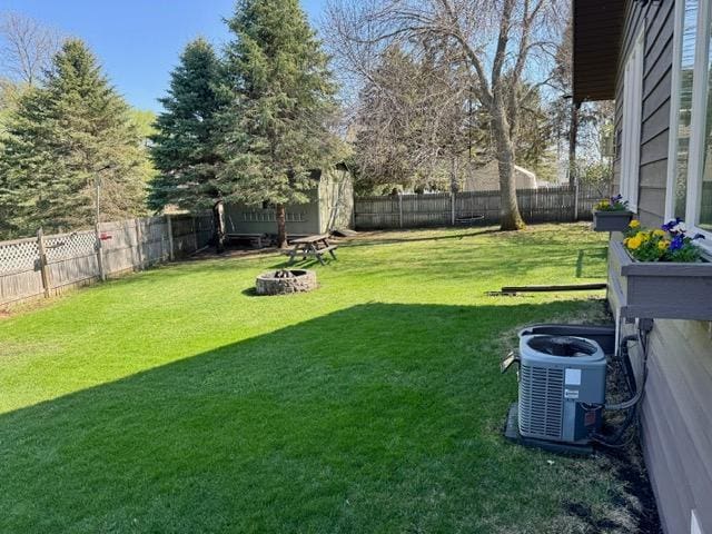 view of yard featuring an outdoor fire pit and central AC unit