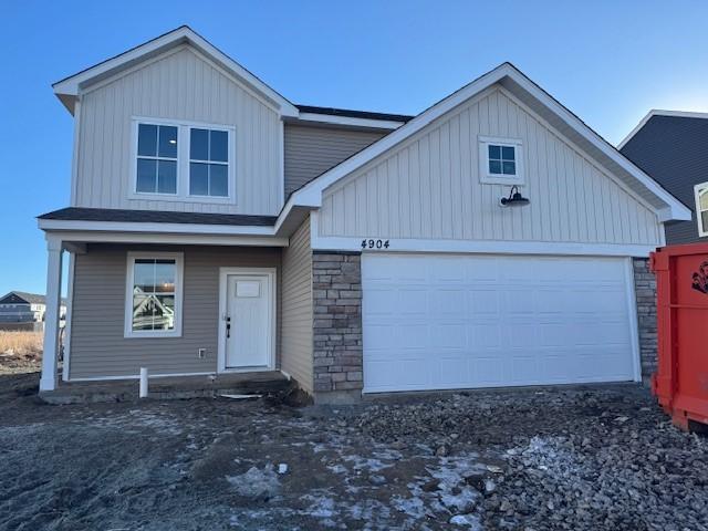 12505 Erskin St NE, Blaine, MN 55449 - view of front facade featuring board and batten siding, stone siding, and a garage