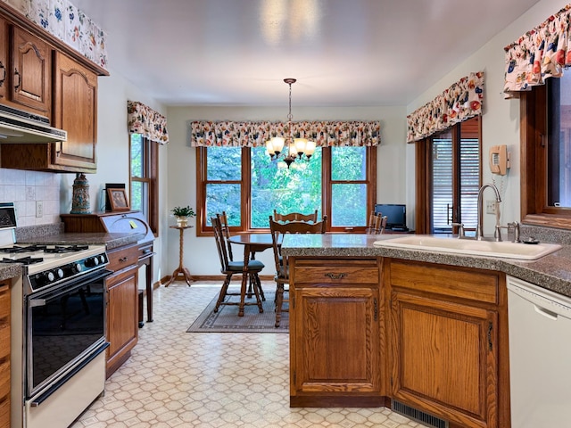 1626 Diane Rd, Mendota Heights, MN 55118 - kitchen with range with gas stovetop, white dishwasher, a sink, a chandelier, and decorative backsplash