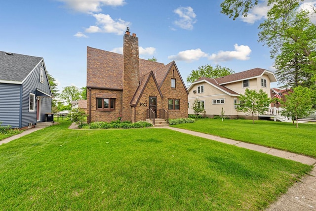 209 Main St, Arlington, MN 55307 - english style home featuring a front yard, brick siding, and a chimney