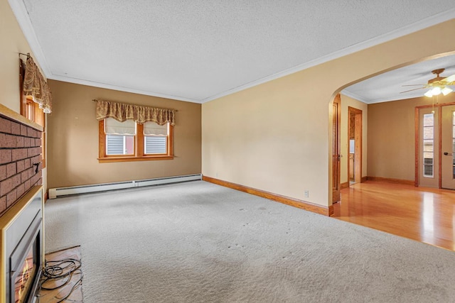 209 Main St, Arlington, MN 55307 - spare room featuring a brick fireplace, a baseboard heating unit, carpet floors, arched walkways, and ornamental molding
