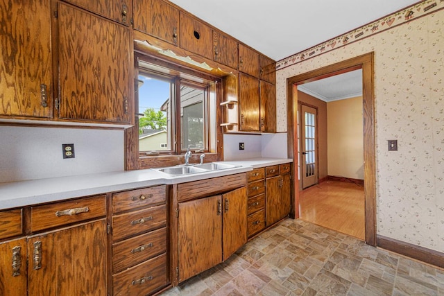 209 Main St, Arlington, MN 55307 - kitchen featuring a sink, wallpapered walls, stone finish floors, light countertops, and baseboards