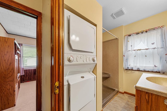 209 Main St, Arlington, MN 55307 - laundry room featuring stacked washing machine and dryer and baseboards