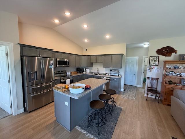 2008 Whiting Rd NW Unit 26, Bemidji, MN 56601 - kitchen with appliances with stainless steel finishes, a center island, light wood-style floors, a kitchen breakfast bar, and a sink