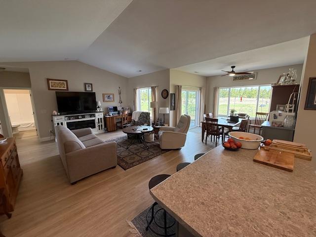 2008 Whiting Rd NW Unit 26, Bemidji, MN 56601 - living room featuring light wood finished floors, healthy amount of natural light, vaulted ceiling, and ceiling fan