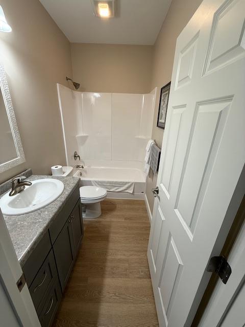 2008 Whiting Rd NW Unit 26, Bemidji, MN 56601 - bathroom featuring toilet, vanity, shower / tub combination, and wood finished floors