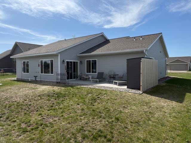 2008 Whiting Rd NW Unit 26, Bemidji, MN 56601 - back of property with a patio area, a yard, and roof with shingles