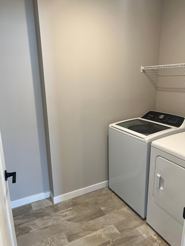 12608 Erskin St NE, Blaine, MN 55449 - laundry room featuring washer and clothes dryer, stone finish flooring, and baseboards