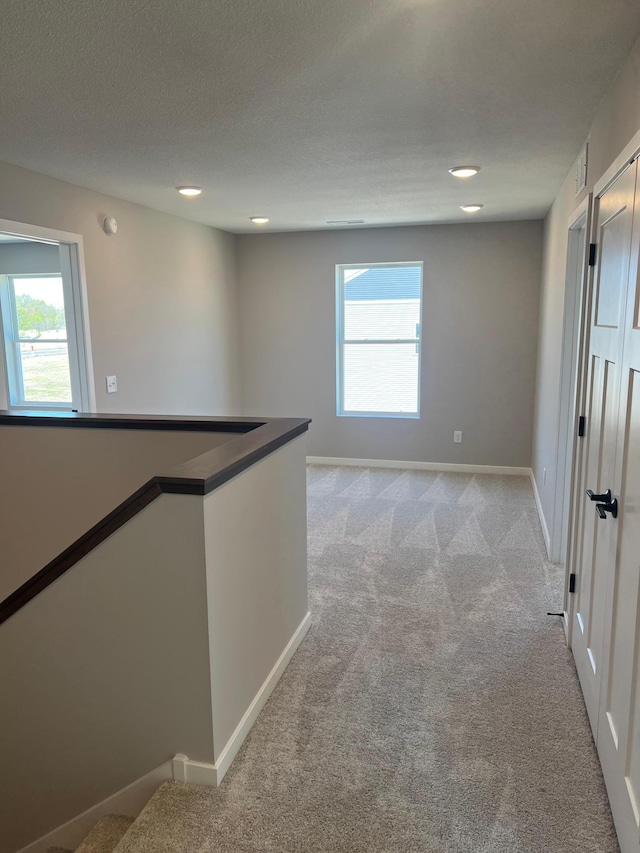 12608 Erskin St NE, Blaine, MN 55449 - hall with light carpet, baseboards, and recessed lighting