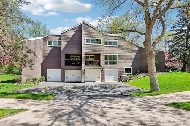 7676 Woodview Ct, Edina, MN 55439 - view of front facade with driveway, an attached garage, a front yard, and central air condition unit
