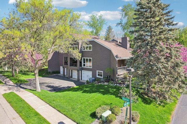 7676 Woodview Ct, Edina, MN 55439 - view of front of home with a garage, central air condition unit, asphalt driveway, a chimney, and a front yard
