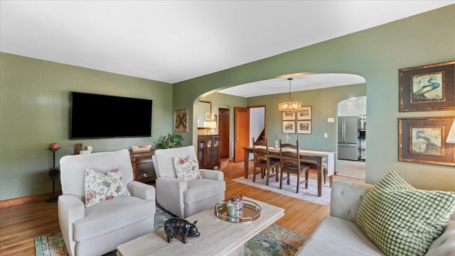 12586 220th St, Silver Lake, MN 55381 - living room featuring arched walkways, light wood-style flooring, and a chandelier