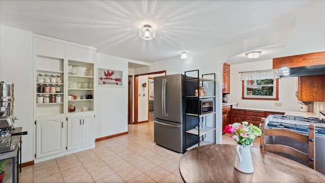 12586 220th St, Silver Lake, MN 55381 - kitchen featuring freestanding refrigerator, arched walkways, light tile patterned floors, light countertops, and premium range hood