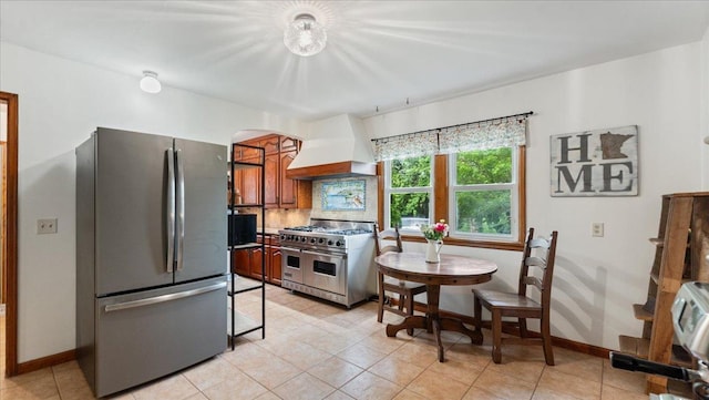 12586 220th St, Silver Lake, MN 55381 - kitchen with appliances with stainless steel finishes, custom exhaust hood, arched walkways, light tile patterned floors, and tasteful backsplash