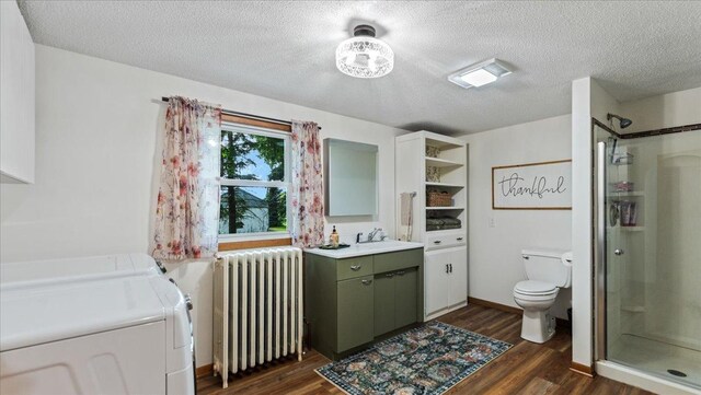 12586 220th St, Silver Lake, MN 55381 - full bathroom with radiator heating unit, washer and clothes dryer, vanity, a stall shower, and wood finished floors