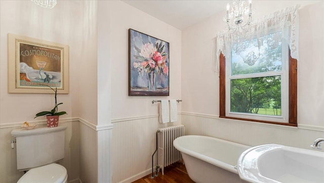 12586 220th St, Silver Lake, MN 55381 - bathroom with radiator, a freestanding bath, a wainscoted wall, and wood finished floors