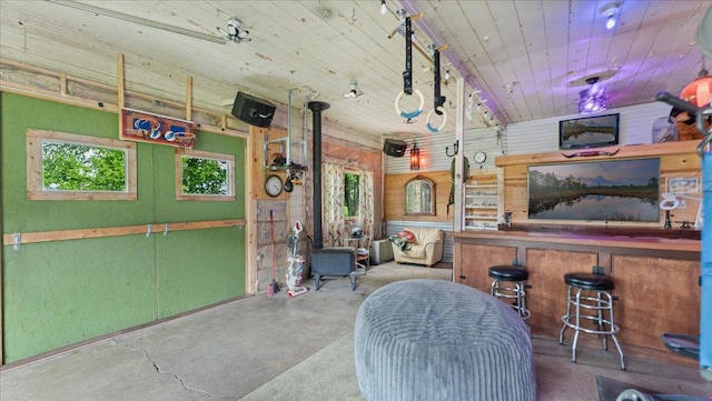 12586 220th St, Silver Lake, MN 55381 - bar with unfinished concrete flooring, a wood stove, and wood ceiling