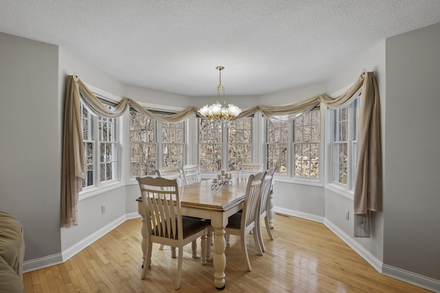 19062 180th Ave NW, Big Lake, MN 55309 - dining space with a chandelier, baseboards, light wood-style flooring, and a textured ceiling