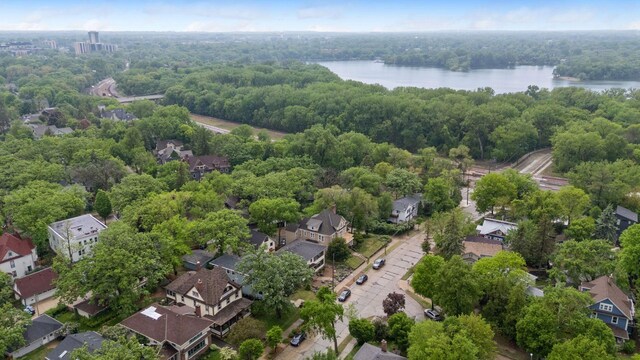 aerial perspective of suburban area featuring a large body of water and a heavily wooded area