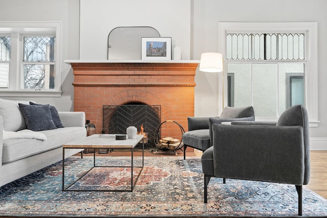 living area with wood finished floors and a brick fireplace