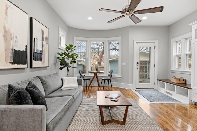 living room with light wood-style flooring, recessed lighting, a ceiling fan, and baseboards