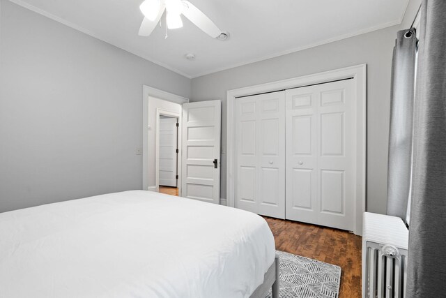 bedroom featuring radiator heating unit, ornamental molding, wood finished floors, a ceiling fan, and a closet