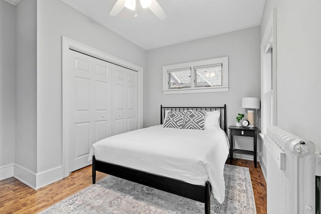 bedroom with a closet, wood finished floors, ceiling fan, and baseboards